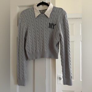 Grey sweater with black embroidered NY logo on collar